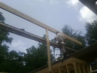 Carpenter setting a ridge beam over a new addition frame — Ice Dam Removal by Roofing Brothers in Platina