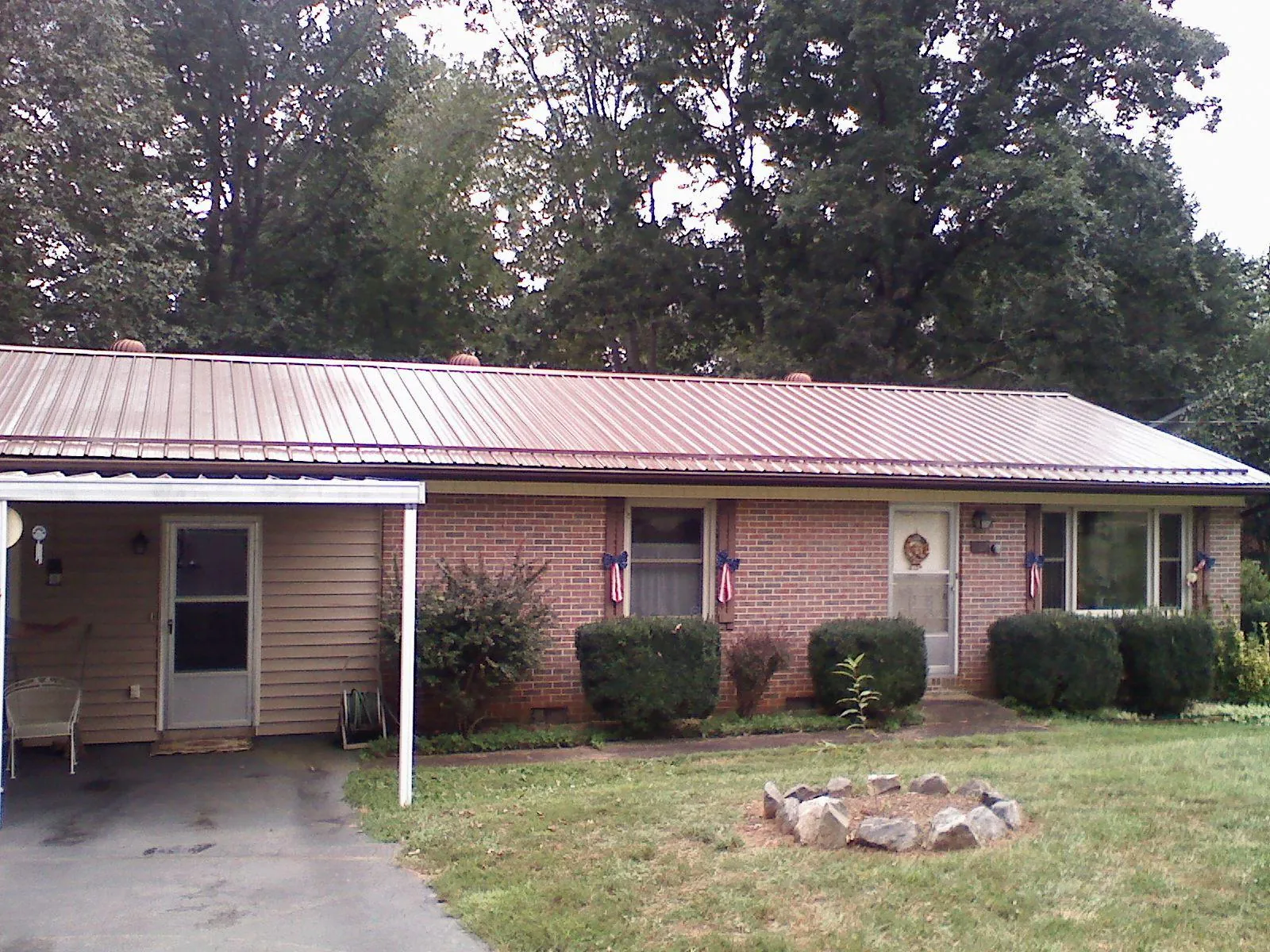 Bronze metal roof and carport on a brick ranch home — Roof Repair work by our crew in Platina